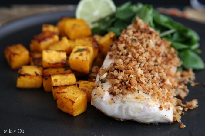 An autumn dish. Close up shot of tarakihi fillet with rosemary lime crumb, roasted butternut squash and watercress salad on black plate. Image: Su Leslie, 2018